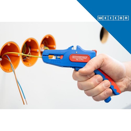 Ruka drži plavi WEICON Wire Stripper No.5 PRO, koji je uklanja izolaciju s žica u narančastim utičnicama.